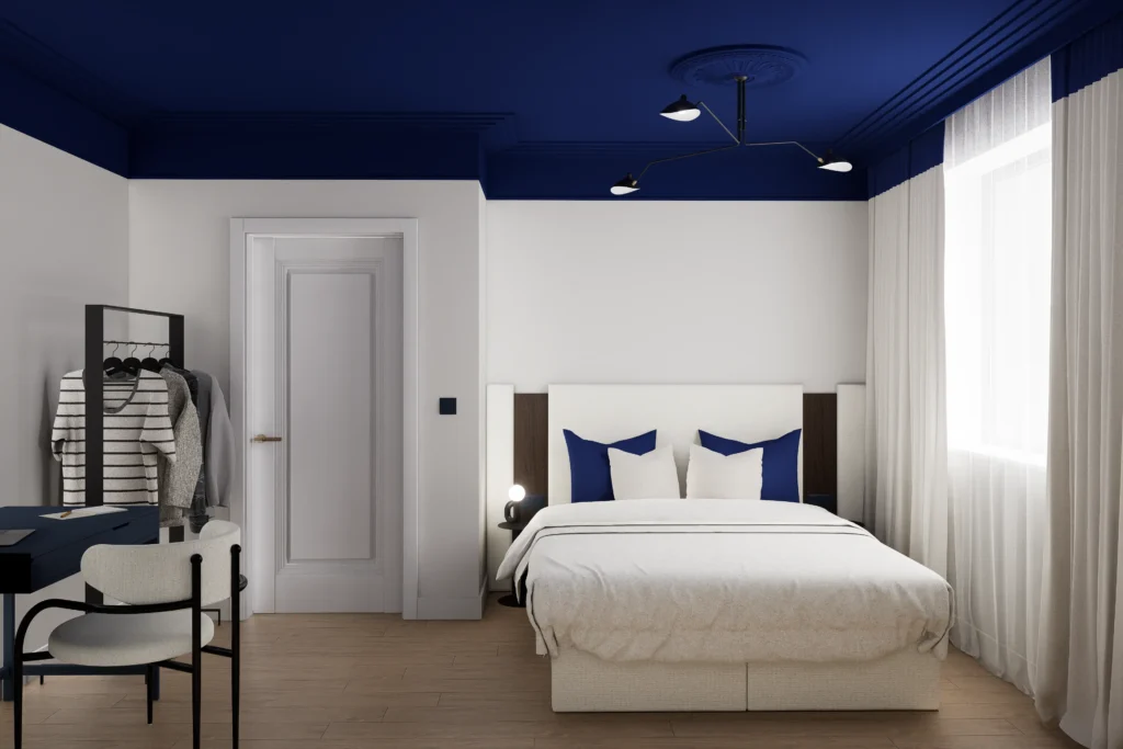 Nowoczesna sypialnia z białym łóżkiem kontynentalnym, drewnianą podłogą i granatowym sufitem, urządzona w minimalistycznym stylu z biurkiem, wieszakiem na ubrania oraz dużym oknem z jasnymi zasłonami, eleganckie wnętrze inspirowane granatową sypialnią